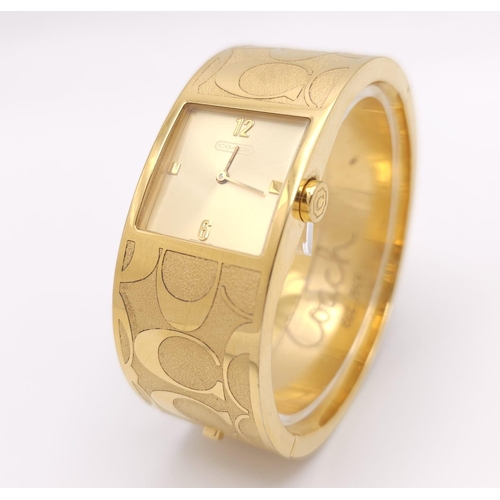 977 - A CLIP BANGLE FASHION WATCH BY COACH , WITH QUARTZ MOVEMENT AND SQUARE GOLD TONE DIAL . COMES WITH O... 