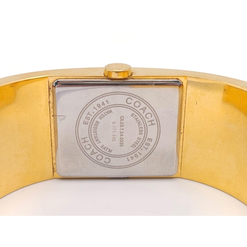 977 - A CLIP BANGLE FASHION WATCH BY COACH , WITH QUARTZ MOVEMENT AND SQUARE GOLD TONE DIAL . COMES WITH O... 