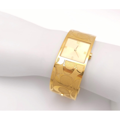 977 - A CLIP BANGLE FASHION WATCH BY COACH , WITH QUARTZ MOVEMENT AND SQUARE GOLD TONE DIAL . COMES WITH O... 