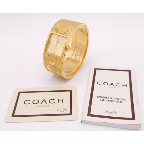 977 - A CLIP BANGLE FASHION WATCH BY COACH , WITH QUARTZ MOVEMENT AND SQUARE GOLD TONE DIAL . COMES WITH O... 