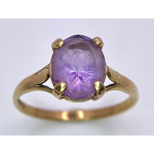 1257 - A 9K GOLD DRESS RING WITH AN OVAL AMETHYST STONE .   1.9gms   size M