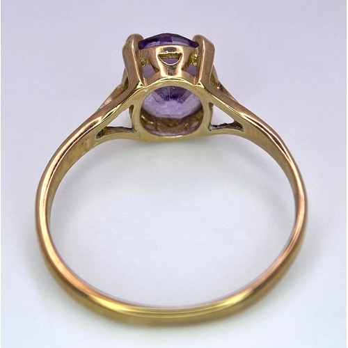 1257 - A 9K GOLD DRESS RING WITH AN OVAL AMETHYST STONE .   1.9gms   size M