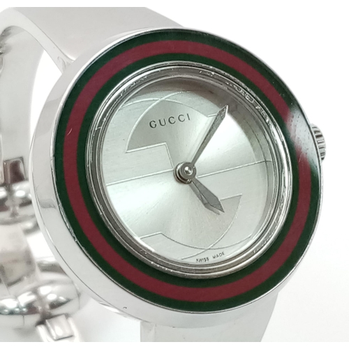 1295 - A Gucci Designer Ladies Quartz Watch. Stainless steel bracelet and case - 27mm. Silver tone dial. In... 