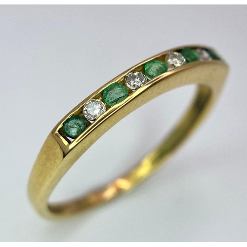 1243 - AN 18K GOLD RING WITH CHANNEL SET EMERALDS AND DIAMONDS .   1.7gms   size L