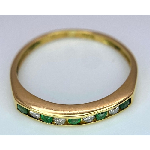 1243 - AN 18K GOLD RING WITH CHANNEL SET EMERALDS AND DIAMONDS .   1.7gms   size L