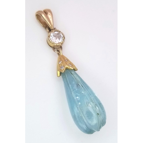 1339 - A CARVED TEAR DROP AQUAMARINE AND DIAMOND PENDANT SET IN HIGH CARAT GOLD .   1.9gms