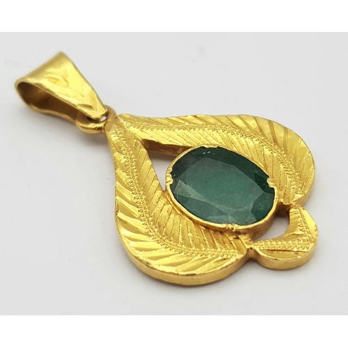 17 - A 22K Yellow Gold and Emerald Pendant. Decorative leaf pattern with a central oval emerald. 4cm. 4.8... 