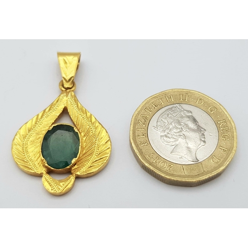 17 - A 22K Yellow Gold and Emerald Pendant. Decorative leaf pattern with a central oval emerald. 4cm. 4.8... 