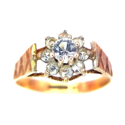 127 - A 9K Yellow Gold Diamond Floral Ring. 0.25ct brilliant round cut central diamond with a diamond halo... 