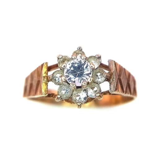 127 - A 9K Yellow Gold Diamond Floral Ring. 0.25ct brilliant round cut central diamond with a diamond halo... 