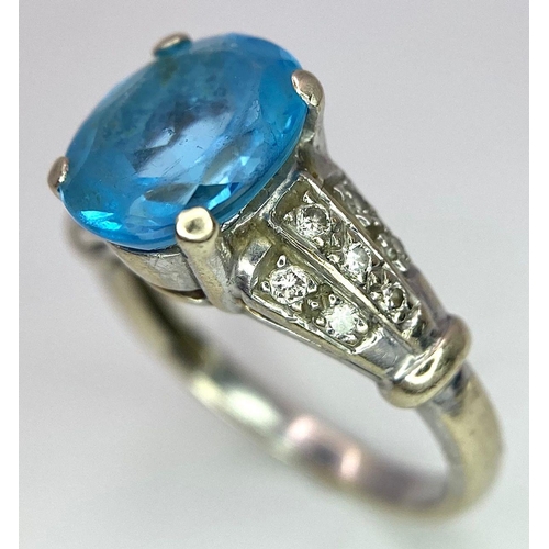 136 - A vintage, 9 K white gold ring with a large, oval cut, vivid blue aquamarine and three bands of diam... 