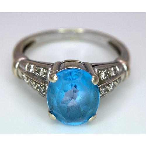 136 - A vintage, 9 K white gold ring with a large, oval cut, vivid blue aquamarine and three bands of diam... 