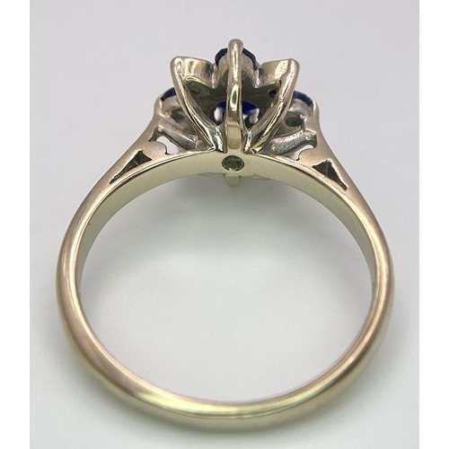 115 - An 18 K white gold ring with a cluster of diamonds and dark blue sapphires.  Size: M, weight: 4 g.