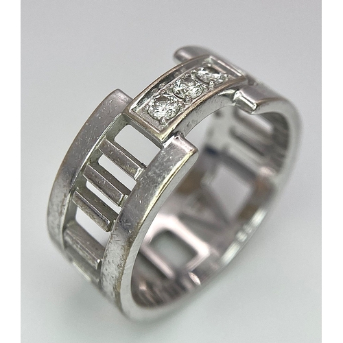 64 - An 18K White Gold Tiffany Atlas Diamond Ring. Pierced Roman numeral decoration. Tiffany mark. Size N... 