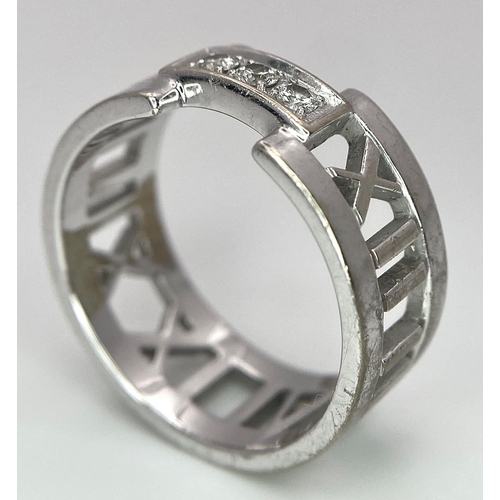 64 - An 18K White Gold Tiffany Atlas Diamond Ring. Pierced Roman numeral decoration. Tiffany mark. Size N... 