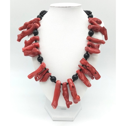 175 - An exotic looking black onyx necklace adorned with large natural red coral pieces from South Pacific... 