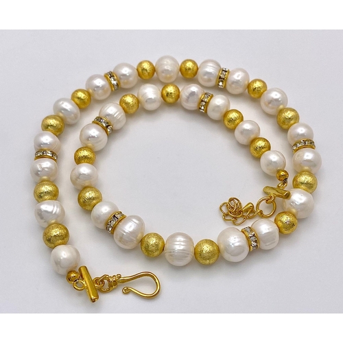 210 - A classy, fresh water cultured white pearl necklace and earrings set, with gold plated parts and cub... 