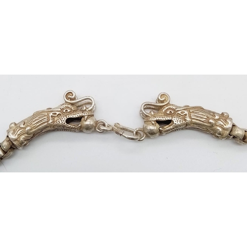 245 - A vintage, Tibetan silver, chain necklace with two dragon heads with a ball in their mouth. Length: ... 