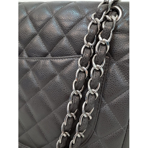 11 - A Chanel Jumbo Double Flap Maxi Bag. Dark grey quilted caviar leather exterior with a large slip poc... 