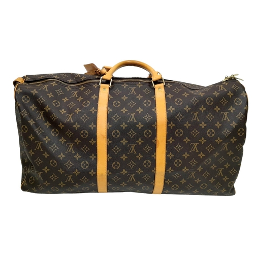 130 - A Louis Vuitton Monogram Keepall 60 Travel Bag. Leather exterior with gold-toned hardware, two rolle... 