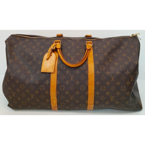 137 - A Large Louis Vuitton Keepall Travel Bag. Monogram LV canvas exterior with cowhide leather handles a... 