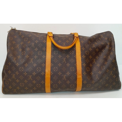 137 - A Large Louis Vuitton Keepall Travel Bag. Monogram LV canvas exterior with cowhide leather handles a... 