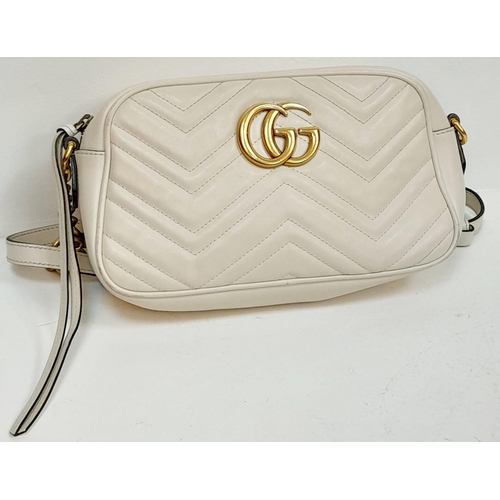 199 - A Gucci Ivory GG Marmont Cross Body Bag. Quilted leather exterior with gold-toned hardware, chain an... 