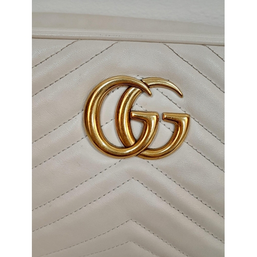 199 - A Gucci Ivory GG Marmont Cross Body Bag. Quilted leather exterior with gold-toned hardware, chain an... 