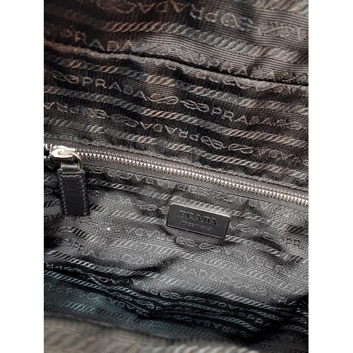 234 - A Prada Black Duffle Bag. Leather exterior with silver-toned hardware, zipped outer compartment to b... 