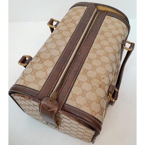 262 - A Gucci Monogram Hard Train Vanity Case. Textile exterior with leather trim, two rolled leather hand... 