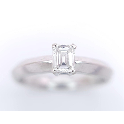 131 - AN 18K WHITE GOLD EMERALD CUT DIAMOND SOLITAIRE RING. 0.34CT. 3.6G. SIZE N.