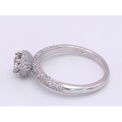 145 - A 14K WHITE GOLD DIAMOND DIAMOND HALO RING WITH FULL SET SHOULDERS AND COLLET. 1.10CT. 2.9G. SIZE M ... 