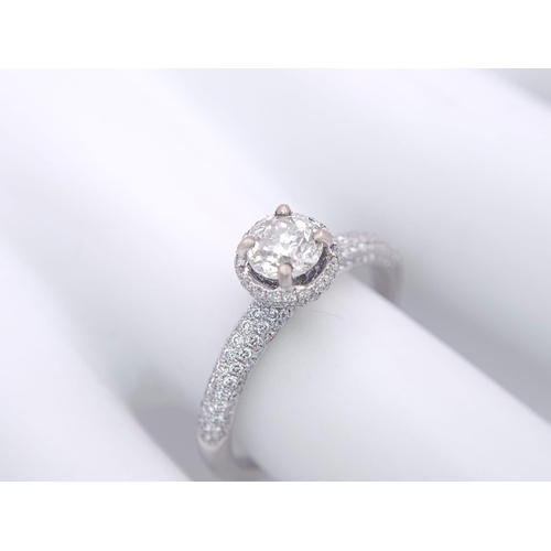 145 - A 14K WHITE GOLD DIAMOND DIAMOND HALO RING WITH FULL SET SHOULDERS AND COLLET. 1.10CT. 2.9G. SIZE M ... 