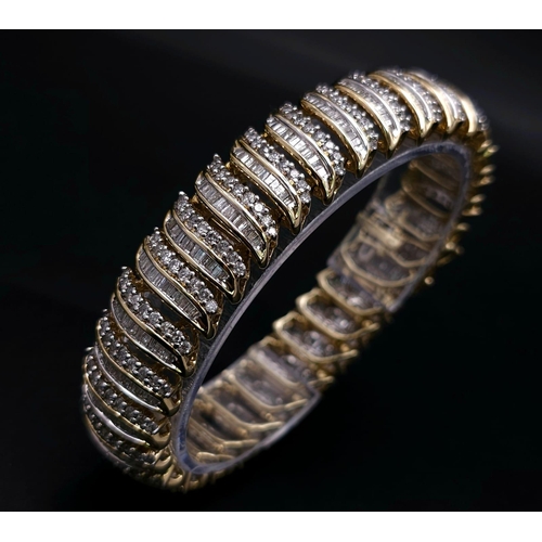 5 - A BEAUTIFUL  HEAD-TURNING 14K YELLOW GOLD DIAMOND TENNIS BRACELET WITH A MIXTURE OF ROUND AND BAGUET... 