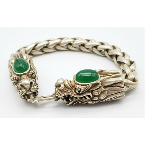 331 - A Tibetan Silver and Green Jade Double Dragon Bracelet. Chinese dragon heads with jade cabochon deco... 