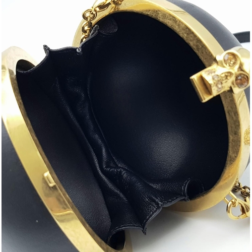 220 - An Alexander Mcqueen Skull Ball Clutch Bag. Black leather exterior with gold tone hardware. Detachab... 