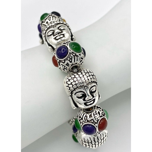 405 - A Tibetan Silver and Multi Coloured Jade Bracelet. Deity shaped links with jade cabochon spaces. Exp... 