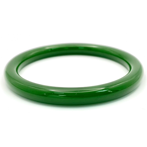 544 - A Spinach Green Chinese Thin Jade Bangle. 7mm width. 60mm inner diameter.