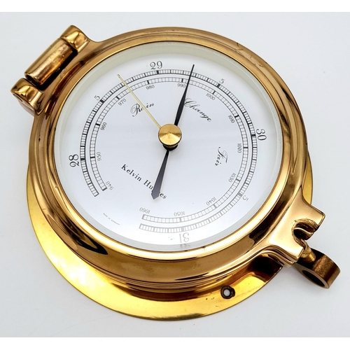 188 - A Nautical, polished brass, KELVIN HUGHES barometer, having the shape of a ship-cabin’s porthole, re... 