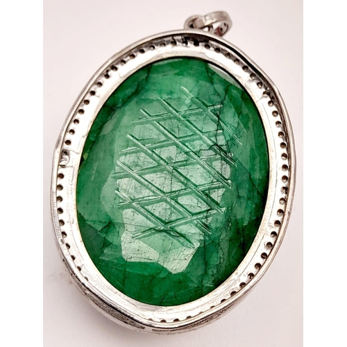 493 - A Silver Carved Emerald Pendant with Rose-Cut Diamond Surround. Oval shaped. 144.25- ctw. Diamonds -... 