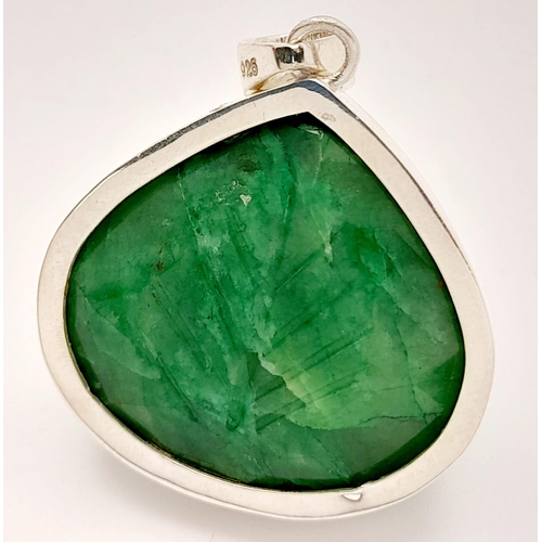 521 - A Carved Trillion Shape 81ct Emerald Pendant set in 925 Silver. 4cm. Comes with a presentation case.... 