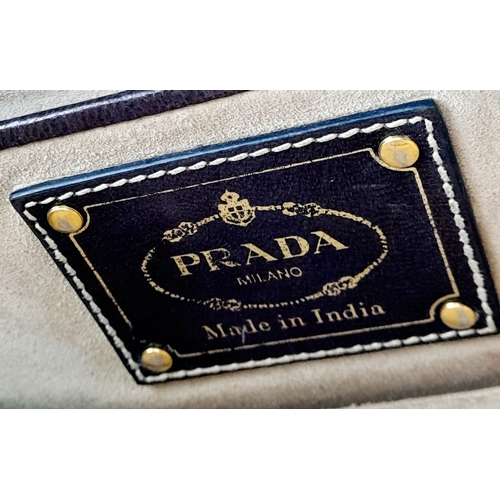 129 - A Prada Black and White 'Madras' Clutch Bag. Woven leather exterior with gold-toned hardware and zip... 