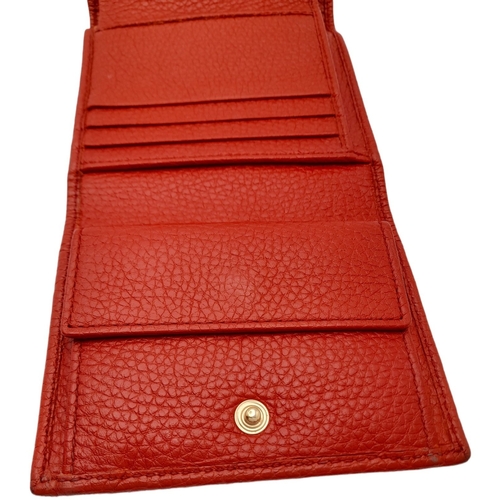 199 - A Gucci Red Trifold Wallet. Leather exterior with the GG logo and press stud closure. Red leather in... 