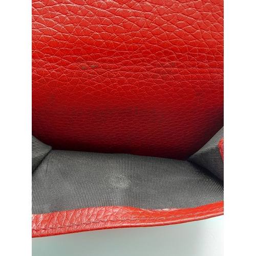 199 - A Gucci Red Trifold Wallet. Leather exterior with the GG logo and press stud closure. Red leather in... 