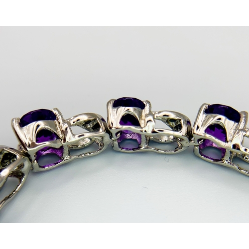 305 - An Amethyst & Sapphire Tennis Bracelet. Set in 925 Sterling silver. 33ctw. W- 24g. 18cm.