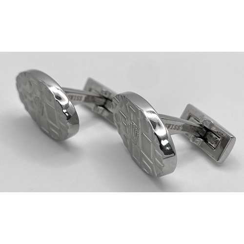 118 - A white metal pair of modern ROLEX cufflinks, in a presentation box (not Rolex). We understand, thes... 