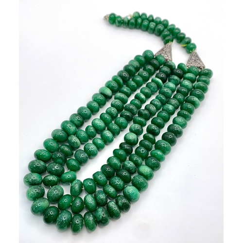 139 - A Tibetan silver necklace with three rows of substantial round emerald cabochons accompanied by a pa... 