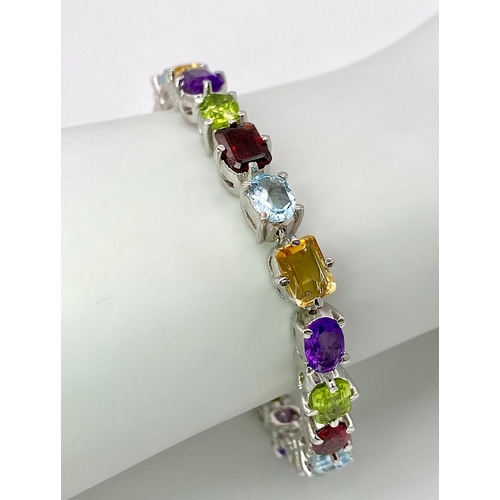 149 - A Multi-Gemstone Bracelet consisting of: Peridots, Amethysts, Blue topaz, Garnet Citrine & Rubies. S... 