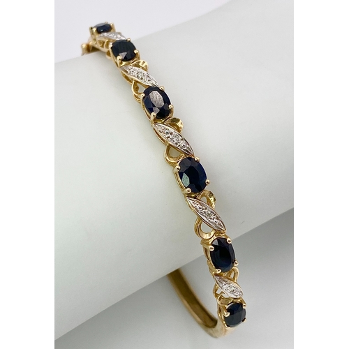 22 - A Vintage 9K Yellow Gold Sapphire and Diamond Bangle. Six oval cut sapphires with diagonal decorativ... 