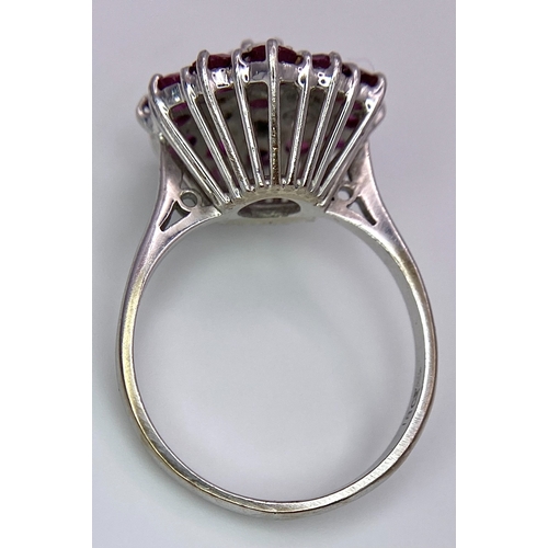 30 - A Gorgeous 18K White Gold, Ruby and Diamond Ring. Floral design on an elevated setting. 14 rubies an... 